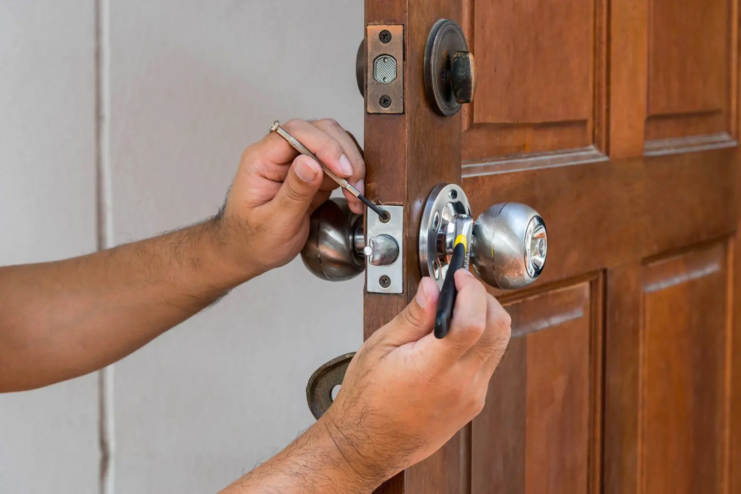 Locksmith installing a residential door lock